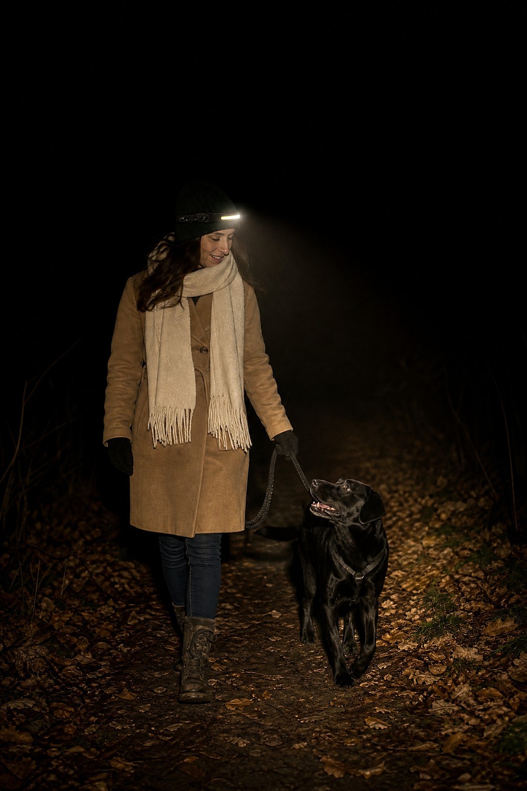 Maître qui promène son chien de nuit avec la lampe Pattelume